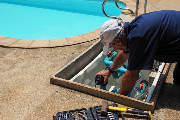 tecnico mentre ripara una pompa della piscina durante manutenzione Dom-us